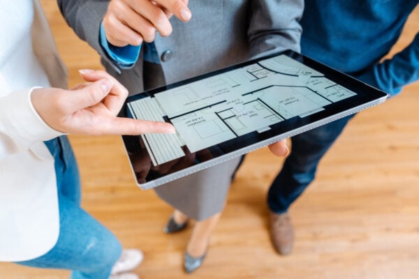 Realtor explaining floor plan to couple renting an apartment.