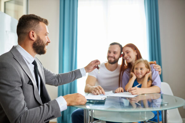 Property manager handing keys to a family during lease signing, representing how to list children as authorized occupants