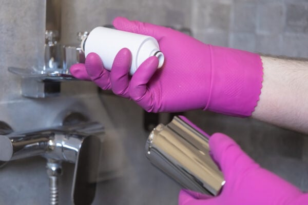 Tenant installing a shower filter to reduce hard water effects in an apartment
