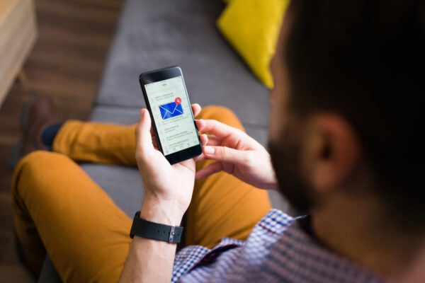 Tenant checking messages on phone while waiting for a response from property management