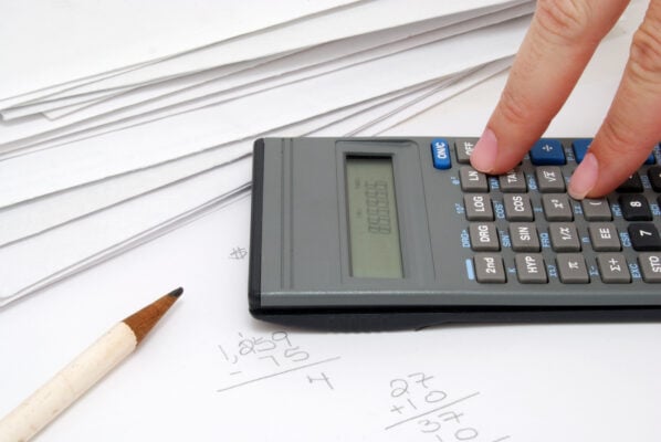 Person using a calculator to add up unpaid rent and fees